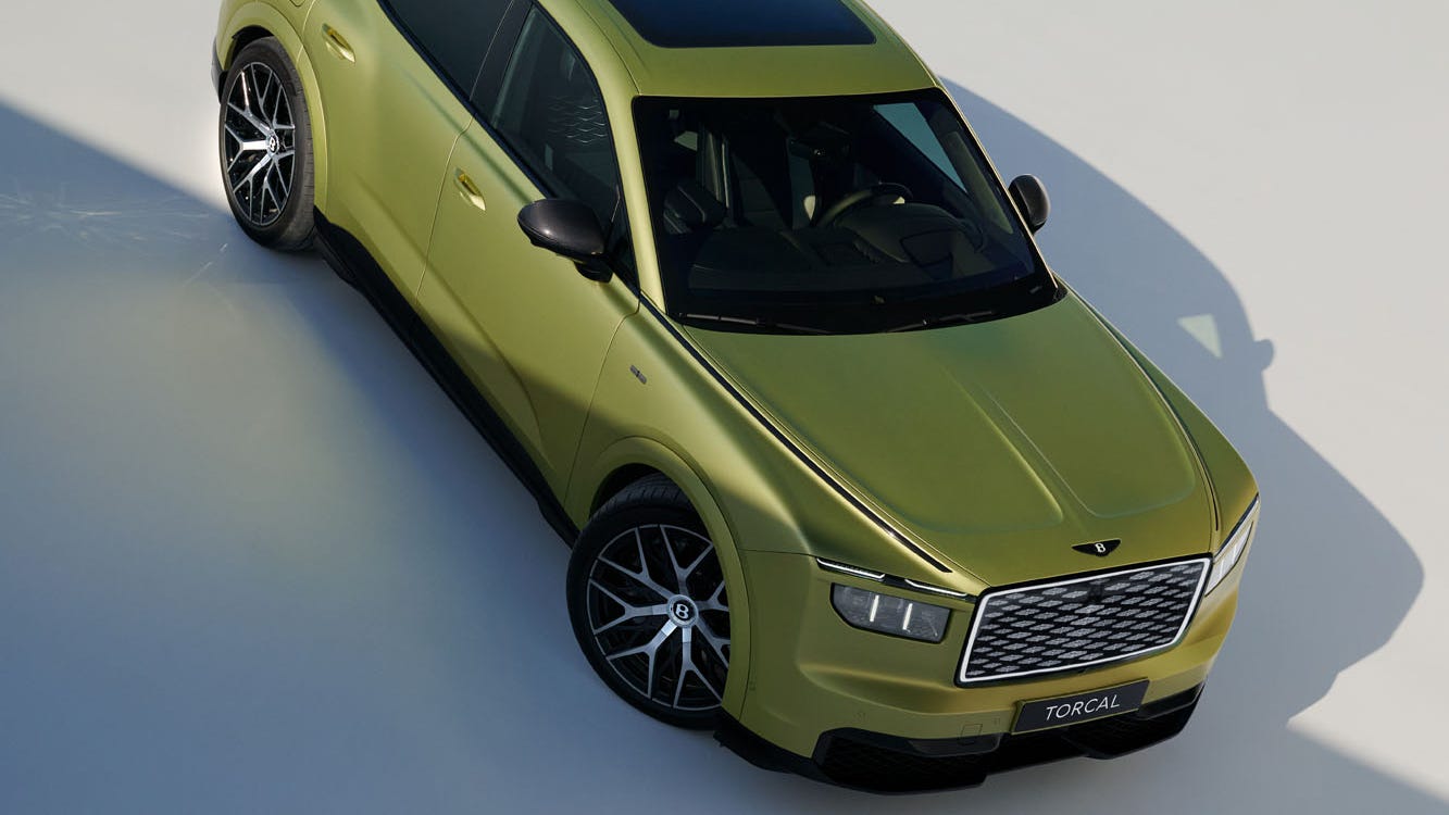 A vibrant green luxury SUV with a sleek design, parked on a light-colored surface.