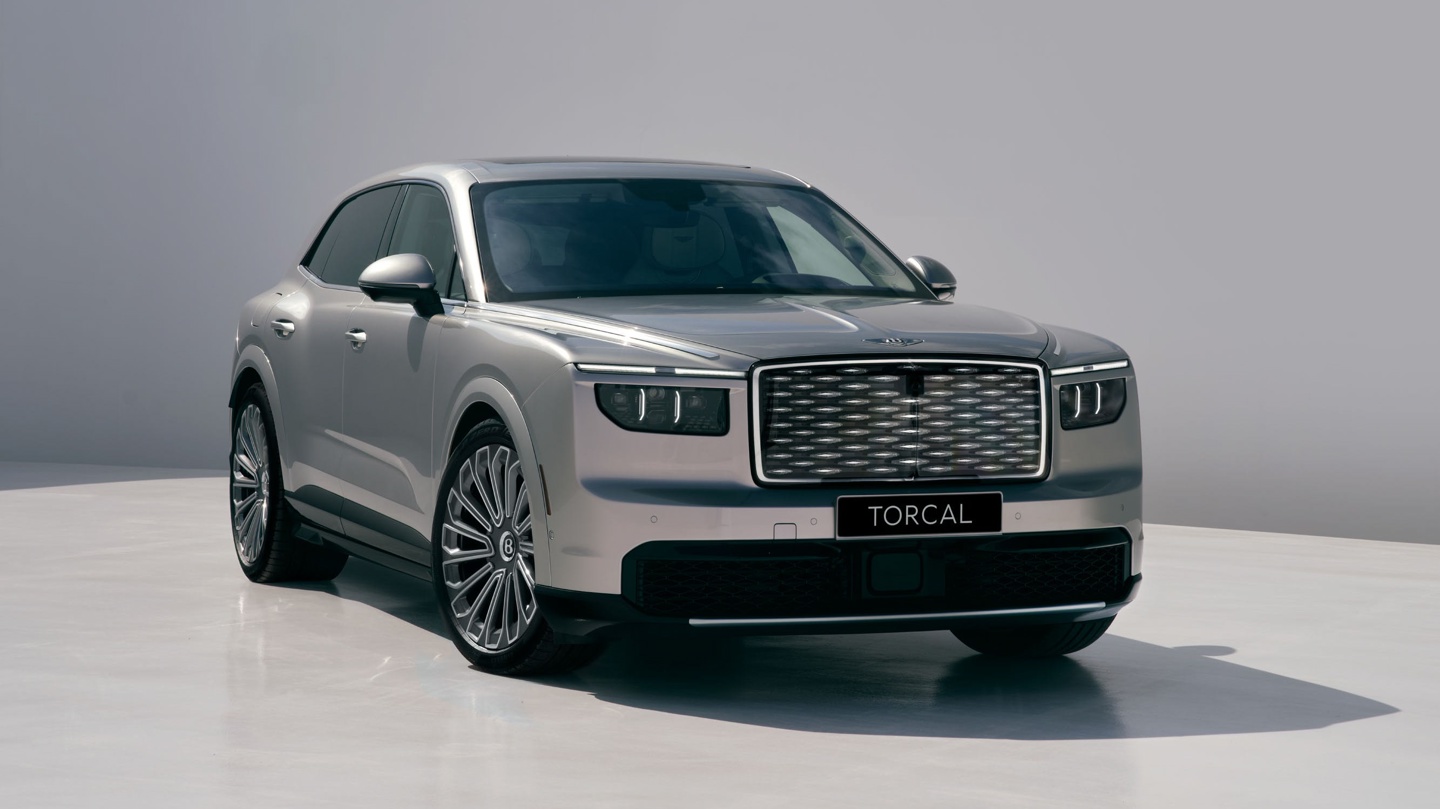 A luxury gray SUV with a distinctive grille and large wheels, parked against a minimalist background.