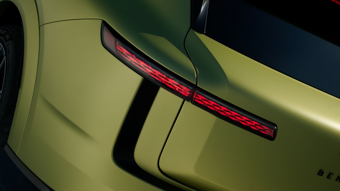 Close-up of a car's rear featuring a unique design and illuminated tail light signals.