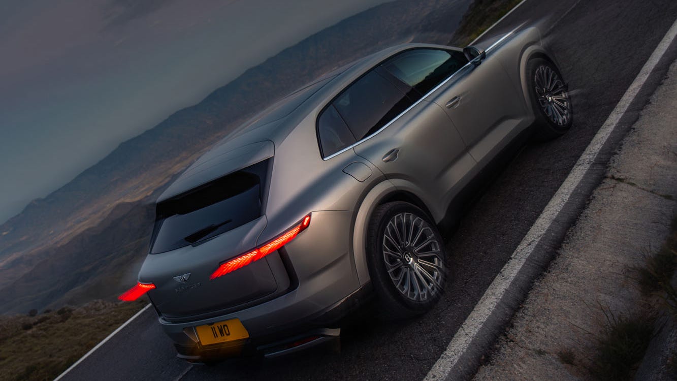 Luxurious SUV parked on a winding mountain road during twilight.