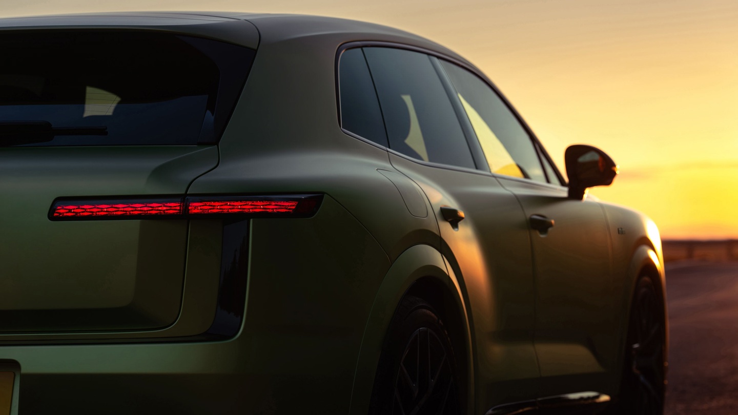 Stylish SUV with glowing red taillights against a sunset backdrop.